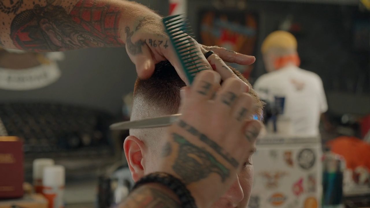 A barber trimming a client's hair