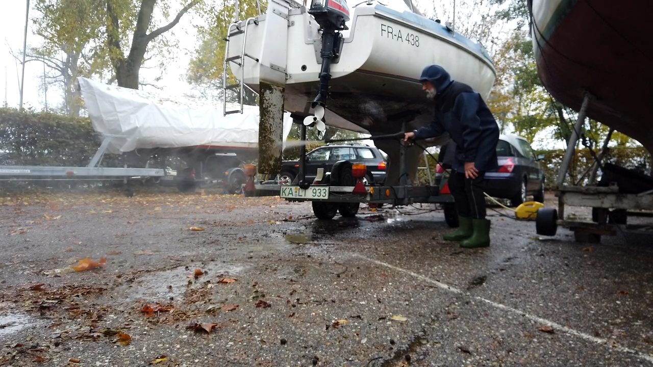 A mechanic washing down a boat hull